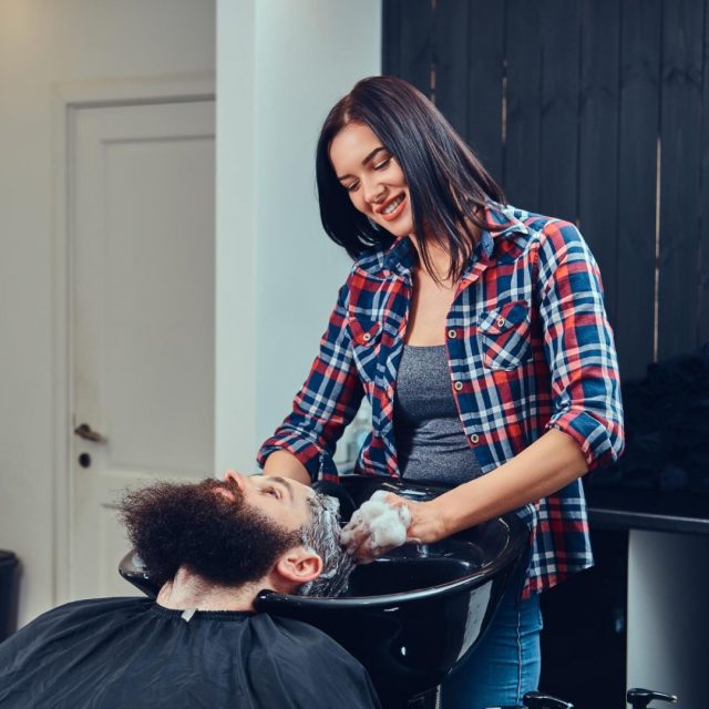 Hairdresser washing clients hair