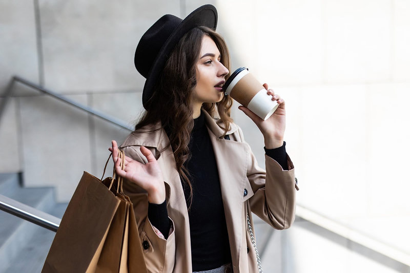 Young woman with shopping bags walking down city street